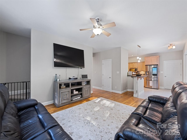 living room with ceiling fan and light wood-type flooring