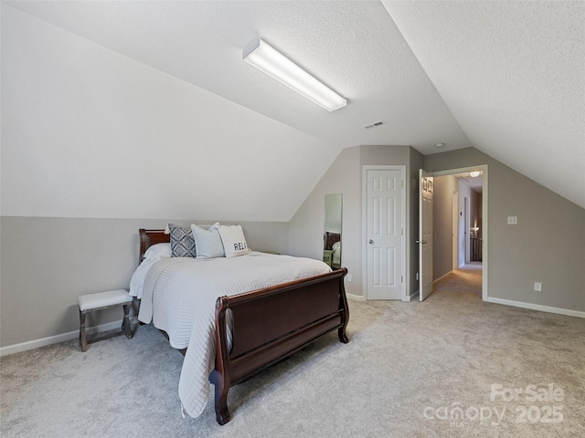 bedroom with light carpet, a textured ceiling, and lofted ceiling