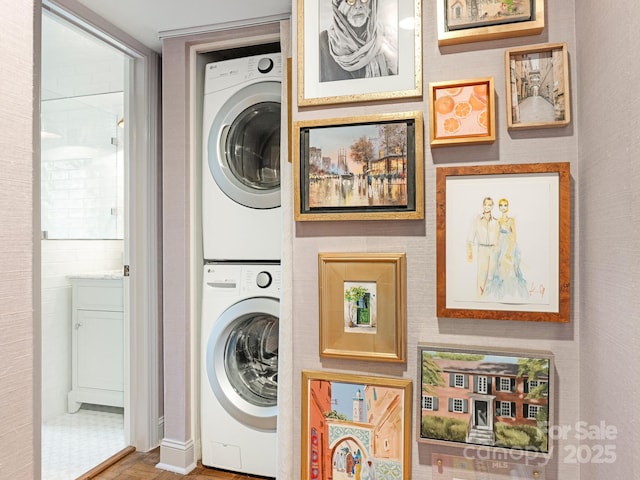 clothes washing area featuring stacked washing maching and dryer