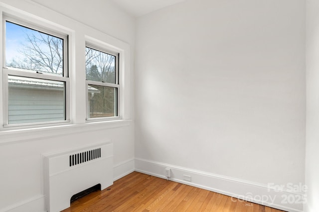 empty room with radiator and wood-type flooring