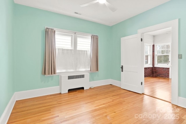 unfurnished bedroom featuring wood-type flooring, radiator heating unit, and ceiling fan