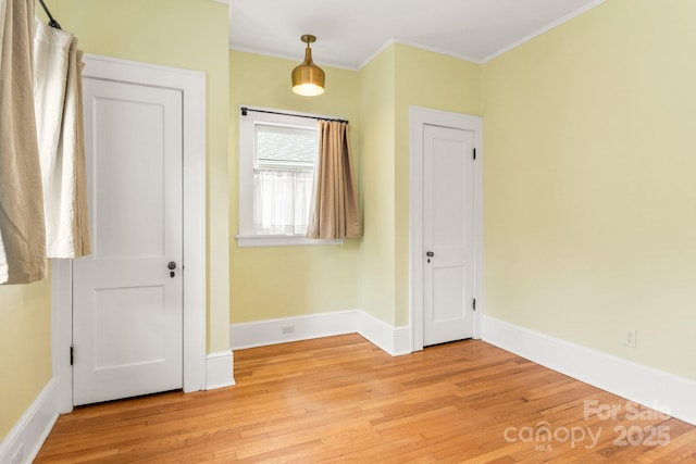 unfurnished bedroom with ornamental molding and light hardwood / wood-style floors