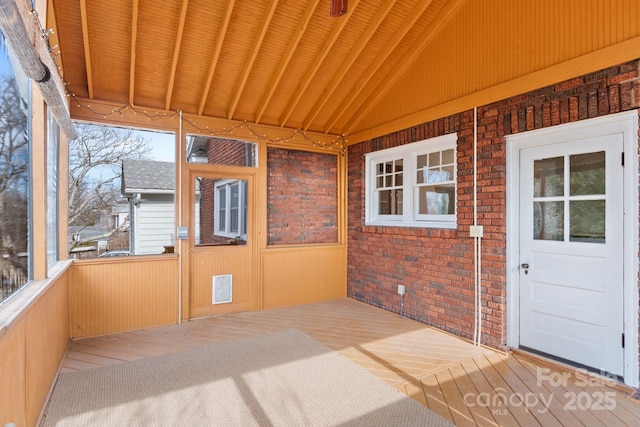 unfurnished sunroom featuring vaulted ceiling and wooden ceiling