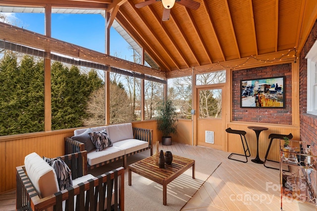 sunroom with lofted ceiling with beams and ceiling fan