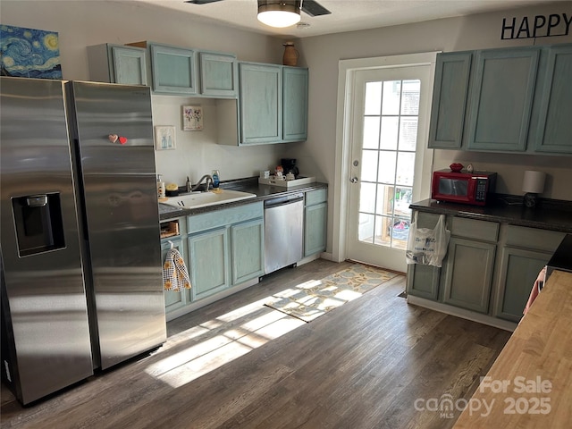 kitchen with ceiling fan, wooden counters, light hardwood / wood-style floors, sink, and stainless steel appliances