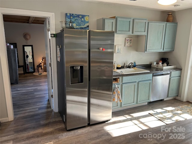 kitchen with sink, stainless steel appliances, and hardwood / wood-style floors