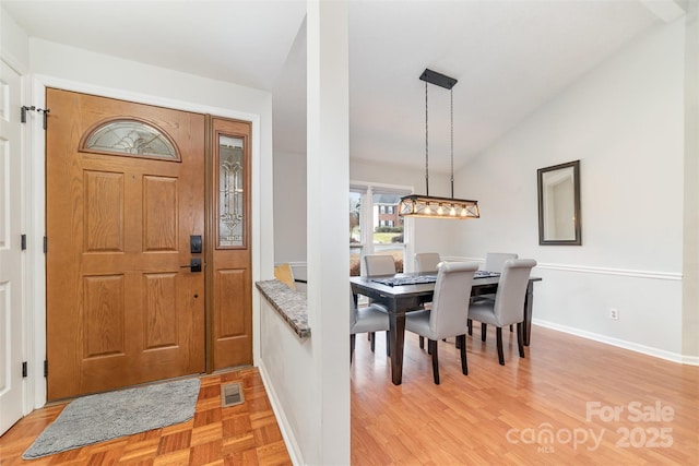 foyer with vaulted ceiling and light wood-type flooring