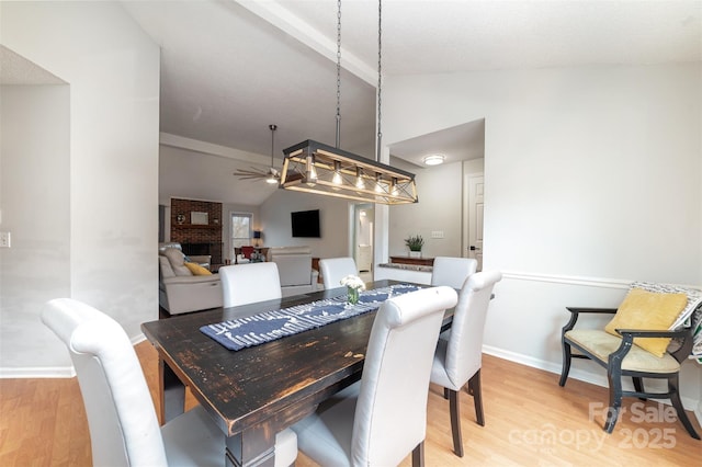 dining space featuring ceiling fan, lofted ceiling, and light wood-type flooring