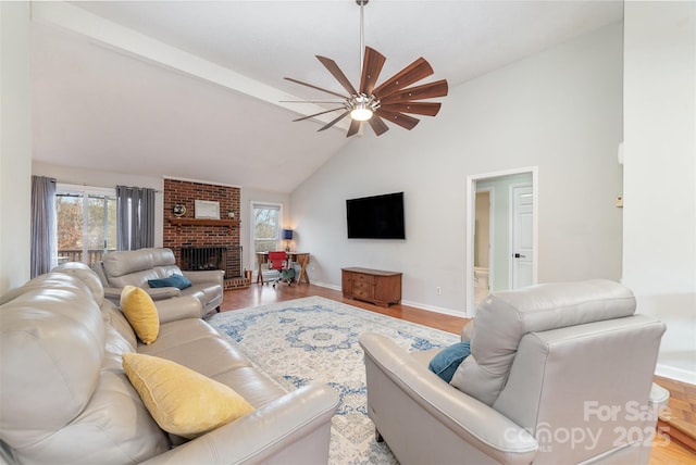 living room with ceiling fan, plenty of natural light, a fireplace, and light wood-type flooring