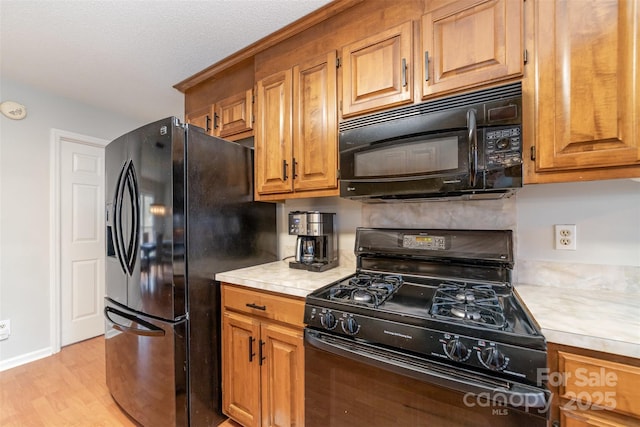 kitchen featuring light hardwood / wood-style floors and black appliances