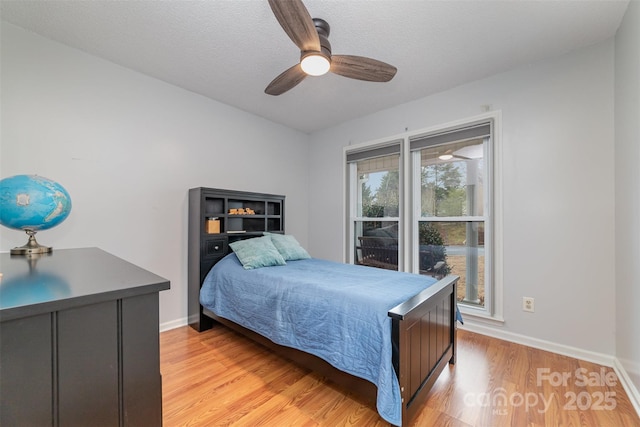 bedroom featuring light wood-type flooring, a textured ceiling, and ceiling fan