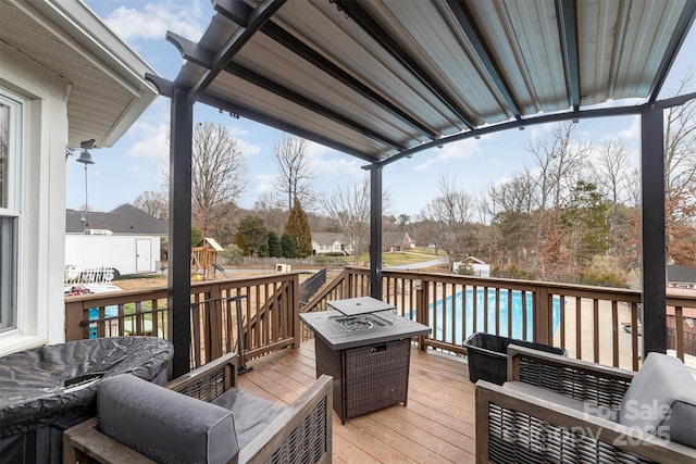 wooden terrace with a playground, an outdoor living space with a fire pit, and a fenced in pool