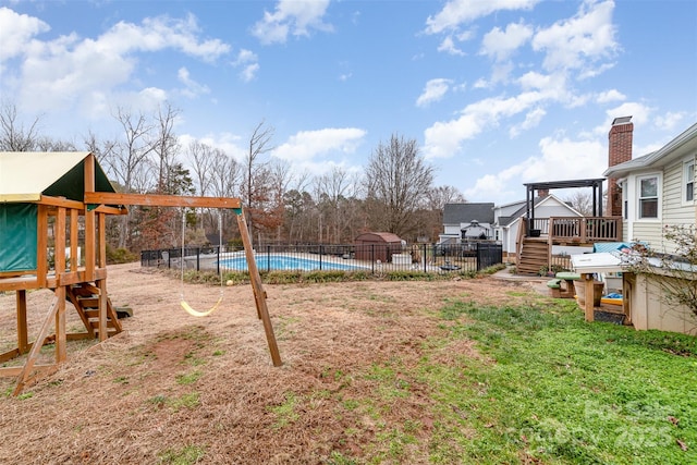 view of yard featuring a pool side deck and a playground