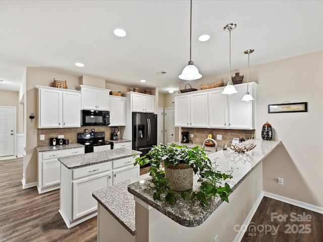 kitchen featuring kitchen peninsula, pendant lighting, white cabinetry, tasteful backsplash, and black appliances