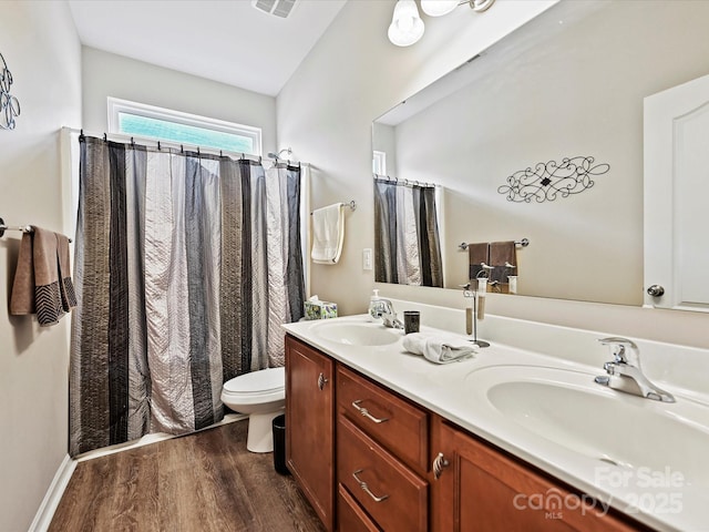 bathroom featuring hardwood / wood-style flooring, toilet, vanity, and lofted ceiling