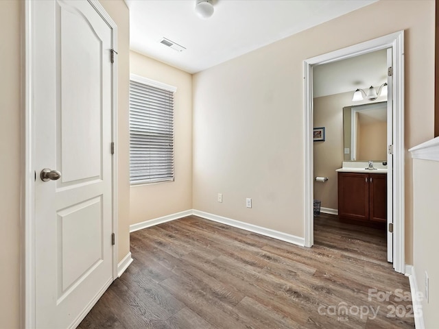 unfurnished bedroom with hardwood / wood-style floors and ensuite bath