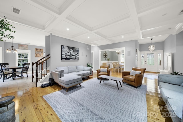 living room with light hardwood / wood-style floors, plenty of natural light, and a notable chandelier