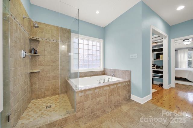 bathroom with ceiling fan, tile patterned floors, and plus walk in shower