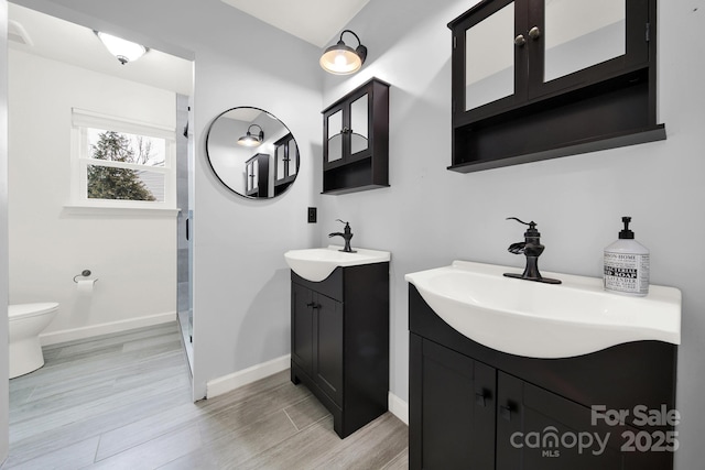 bathroom with vanity, toilet, and hardwood / wood-style flooring