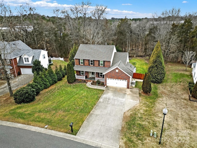 view of front of property with covered porch, a front lawn, and a garage