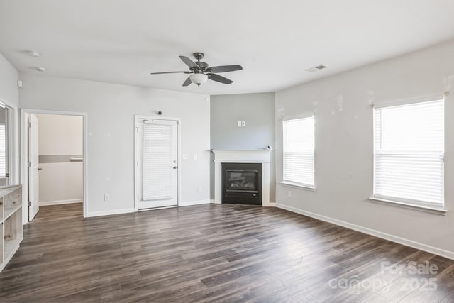 unfurnished living room with ceiling fan and dark wood-type flooring