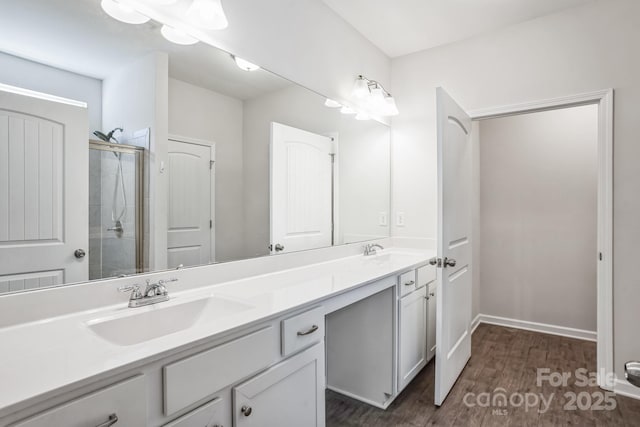 bathroom with vanity, wood-type flooring, and a shower with door