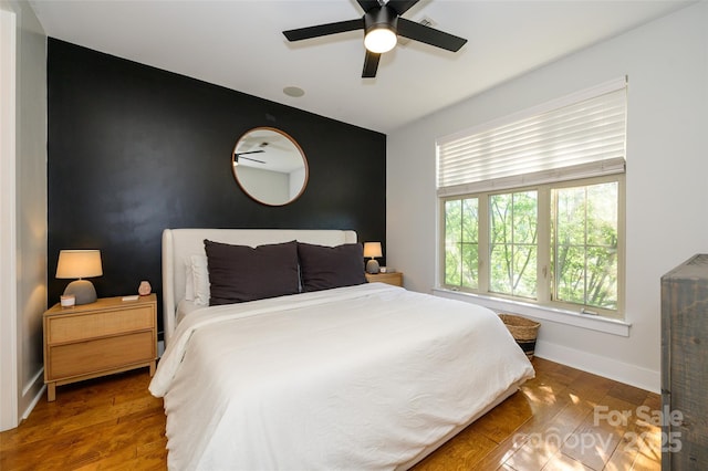 bedroom with ceiling fan and dark hardwood / wood-style flooring