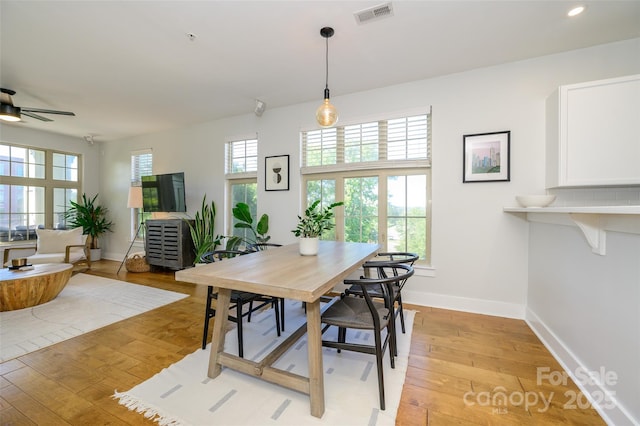 dining room featuring ceiling fan, a healthy amount of sunlight, and light wood-type flooring