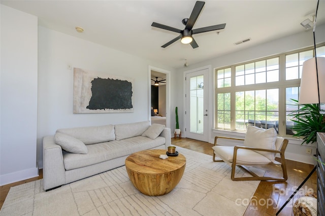 living room featuring ceiling fan, plenty of natural light, and light hardwood / wood-style flooring