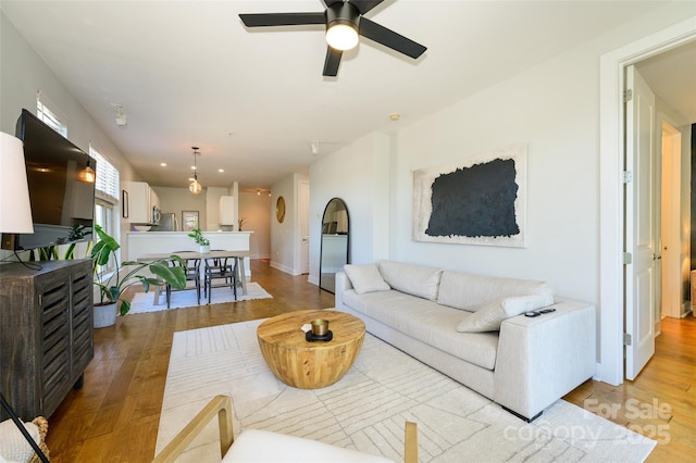 living room with light hardwood / wood-style floors and ceiling fan