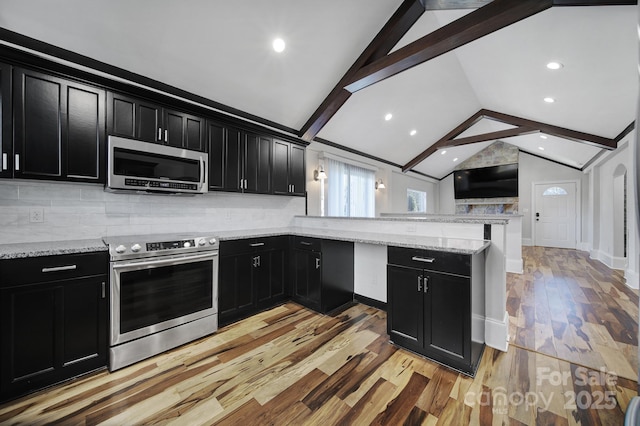 kitchen featuring tasteful backsplash, lofted ceiling with beams, kitchen peninsula, and appliances with stainless steel finishes