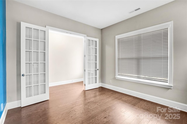 spare room with french doors and dark wood-type flooring