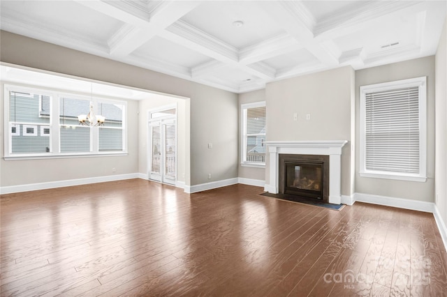 unfurnished living room featuring dark hardwood / wood-style flooring, beam ceiling, a chandelier, and coffered ceiling