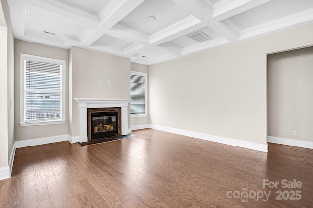 unfurnished living room featuring coffered ceiling, dark hardwood / wood-style floors, beamed ceiling, and a fireplace