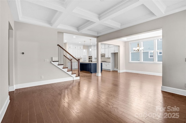 unfurnished living room with a chandelier, coffered ceiling, beamed ceiling, and dark wood-type flooring