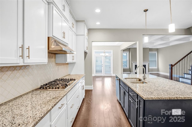 kitchen featuring hanging light fixtures, sink, coffered ceiling, beamed ceiling, and stainless steel appliances