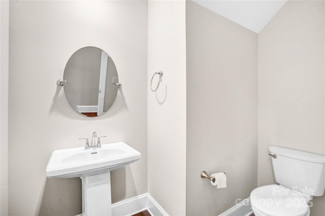 bathroom with toilet and lofted ceiling