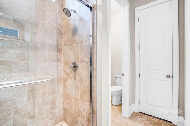 bathroom featuring toilet, tile patterned flooring, and an enclosed shower