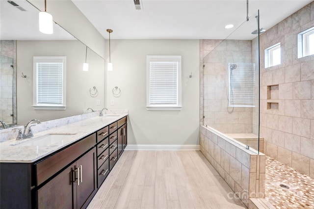 bathroom featuring vanity, hardwood / wood-style flooring, and a tile shower