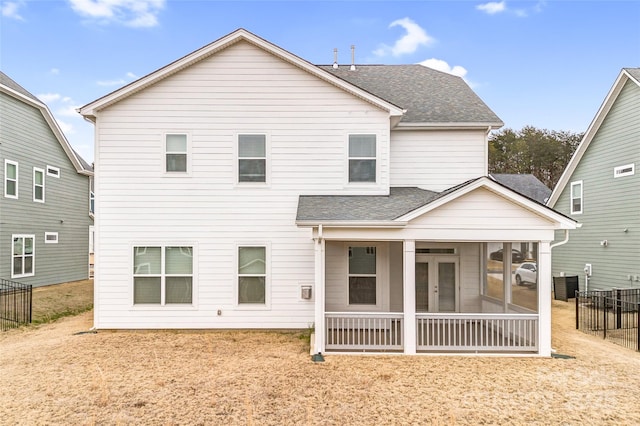 rear view of house featuring a sunroom and a yard