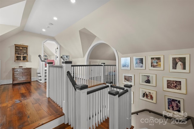 stairs featuring lofted ceiling and hardwood / wood-style flooring