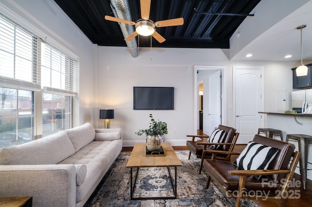 living room with beamed ceiling, ceiling fan, and dark hardwood / wood-style flooring