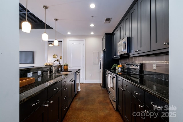 kitchen with appliances with stainless steel finishes, sink, dark stone countertops, backsplash, and hanging light fixtures