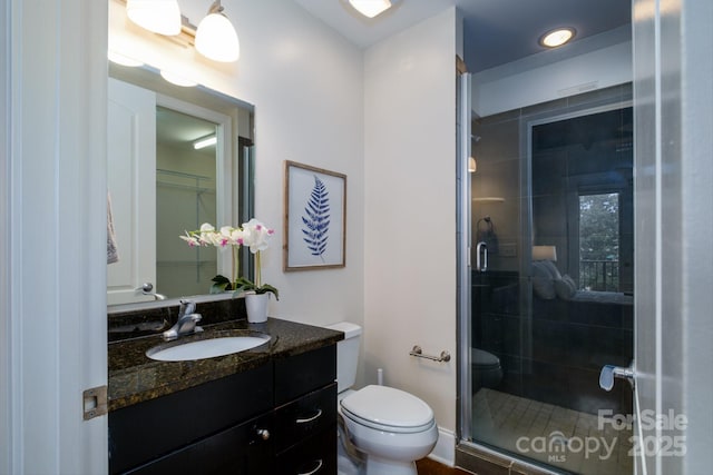 bathroom featuring vanity, toilet, and an enclosed shower