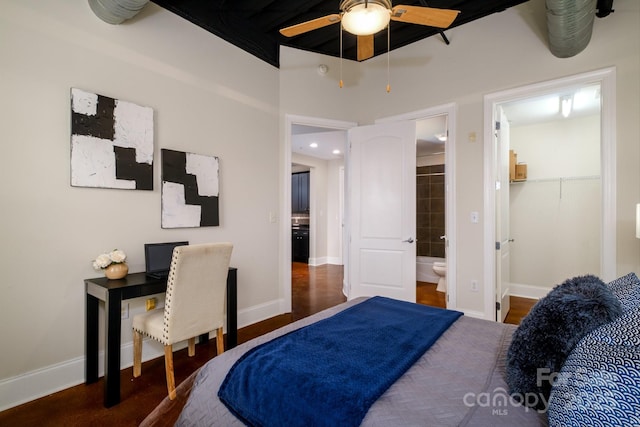 bedroom with a walk in closet, connected bathroom, and dark hardwood / wood-style floors