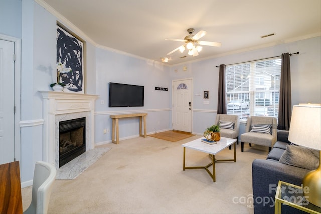 carpeted living room with ceiling fan, ornamental molding, and a fireplace