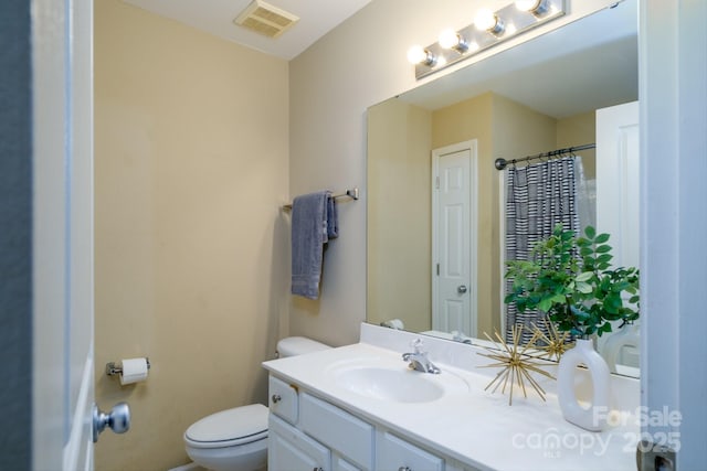 bathroom with toilet, vanity, and a shower with shower curtain