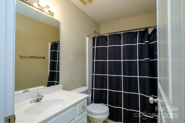 bathroom with toilet, vanity, and a shower with shower curtain