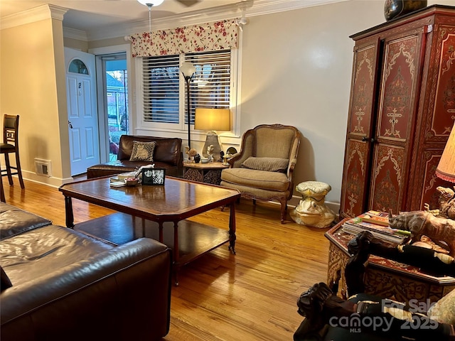 sitting room featuring ornamental molding and light wood-type flooring