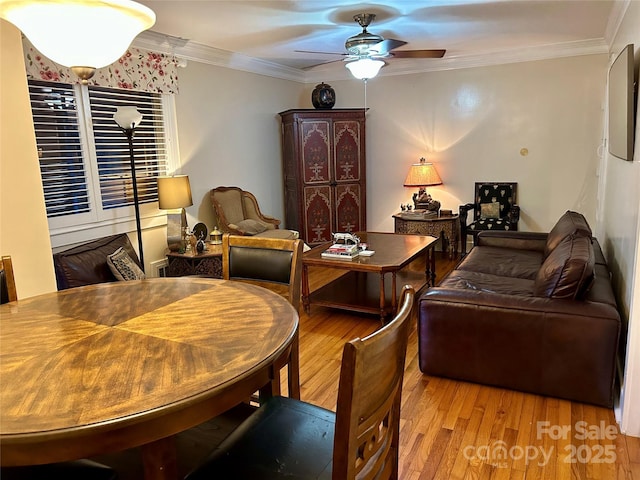 living room featuring crown molding, light hardwood / wood-style floors, and ceiling fan